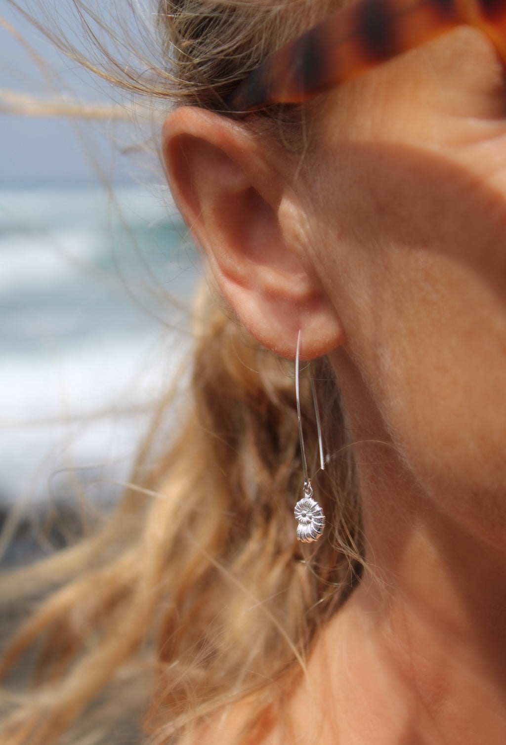 close up of model wearing seashell earring